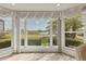 Large bay window with decorative drapes overlooking a manicured lawn and water feature at 6702 Drewrys Blf, Bradenton, FL 34203