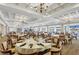 An elegant dining room with chandeliers, large windows, and beautifully set tables at 6702 Drewrys Blf, Bradenton, FL 34203