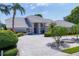 Expansive single-story home with manicured landscaping, water feature, and long paver driveway at 6702 Drewrys Blf, Bradenton, FL 34203