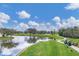 Picturesque golf course view with a calm pond reflecting the sky, lush greens, and winding cart paths at 6702 Drewrys Blf, Bradenton, FL 34203