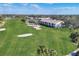 An aerial view of a lush golf course with manicured greens, sand traps, and a pond near a residential area at 6702 Drewrys Blf, Bradenton, FL 34203