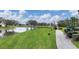 A serene view of a golf course with a pond, a winding path, and golf carts on a partly cloudy day at 6702 Drewrys Blf, Bradenton, FL 34203