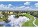 A sweeping view of a golf course pond, lush greens, with cart paths, and scattered trees under a partly cloudy sky at 6702 Drewrys Blf, Bradenton, FL 34203