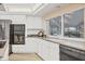 Bright kitchen offering white cabinets and modern appliances overlooking the lanai at 6702 Drewrys Blf, Bradenton, FL 34203