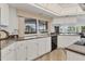 Spacious kitchen featuring white cabinets and countertops with view of lanai at 6702 Drewrys Blf, Bradenton, FL 34203