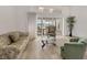 Bright living room featuring modern furnishings and sliding glass doors to outdoor patio at 6702 Drewrys Blf, Bradenton, FL 34203