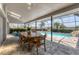 Enclosed patio featuring a dining table and chairs overlooking a swimming pool and lush landscaping at 6702 Drewrys Blf, Bradenton, FL 34203