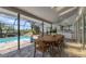 Covered patio with dining table, summer kitchen and screened-in pool area with lush landscaping at 6702 Drewrys Blf, Bradenton, FL 34203