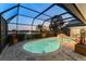 Enclosed patio features a pool, hot tub, and views of the lake and lush landscape at 6702 Drewrys Blf, Bradenton, FL 34203