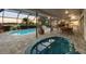 Enclosed patio features a pool, hot tub, and outdoor dining area with views of the lake and lush landscape at 6702 Drewrys Blf, Bradenton, FL 34203