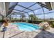 Screened-in pool area with lush landscaping, stone accents, and a view of the surrounding neighborhood at 6702 Drewrys Blf, Bradenton, FL 34203