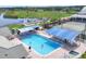 Aerial view of a community pool, tennis court, and other recreational facilities by a lake at 6702 Drewrys Blf, Bradenton, FL 34203