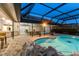 Gorgeous screened-in pool with rock feature, steps, and patio furniture at 6702 Drewrys Blf, Bradenton, FL 34203