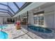 Outdoor enclosed patio featuring a pool, hot tub, and ample seating areas for relaxation and entertaining at 6702 Drewrys Blf, Bradenton, FL 34203