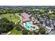 A beautiful aerial view of the clubhouse and resort style pool complete with palm trees and golf course at 7120 Quiet Creek Dr, Bradenton, FL 34212