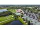 Aerial view of a country club featuring a pool, tennis courts, a clubhouse, a golf course, and a lake at 7120 Quiet Creek Dr, Bradenton, FL 34212