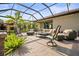 Spacious screened patio featuring comfortable seating, a ceiling fan, and well-manicured landscaping at 7120 Quiet Creek Dr, Bradenton, FL 34212