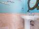 Charming pedestal sink in a bathroom with decorative fish accents and coral-inspired mirror at 7333 Point Of Rocks Rd, Sarasota, FL 34242