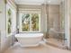 Spa-like bathroom with a standalone soaking tub and a glass enclosed shower with a bench at 7333 Point Of Rocks Rd, Sarasota, FL 34242