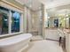 A luxurious bathroom showcasing a soaking tub, glass enclosed shower, and double vanity at 7333 Point Of Rocks Rd, Sarasota, FL 34242