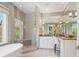 Bright bathroom with a glass enclosed shower, a soaking tub, and vanity with white cabinetry at 7333 Point Of Rocks Rd, Sarasota, FL 34242