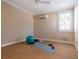 Bright bedroom featuring wood-look floors, neutral walls, a ceiling fan, and fitness equipment at 7333 Point Of Rocks Rd, Sarasota, FL 34242