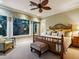 Cozy bedroom features a king-sized bed, ceiling fan, large windows and bathroom access at 7333 Point Of Rocks Rd, Sarasota, FL 34242