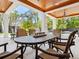 Covered patio with wood ceiling, dining table and view to the pool at 7333 Point Of Rocks Rd, Sarasota, FL 34242