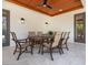 Covered patio with wood ceiling, dining table and views to the yard at 7333 Point Of Rocks Rd, Sarasota, FL 34242