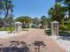 Charming driveway entrance featuring brick pavers, decorative pillars, and lush landscaping leading to the home at 7333 Point Of Rocks Rd, Sarasota, FL 34242