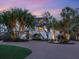 A luxurious home with a circular brick driveway is surrounded by mature palms at 7333 Point Of Rocks Rd, Sarasota, FL 34242