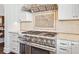 Close-up of the stainless steel range, tile backsplash, and custom cabinets at 7333 Point Of Rocks Rd, Sarasota, FL 34242