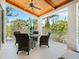 Covered lanai with outdoor seating, ceiling fan, and treed views at 7333 Point Of Rocks Rd, Sarasota, FL 34242