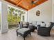 Covered outdoor lanai featuring comfortable seating, ceiling fan, and wooded views at 7333 Point Of Rocks Rd, Sarasota, FL 34242