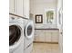 Well-lit laundry room with modern washer/dryer units, built-in cabinets, and a sink at 7333 Point Of Rocks Rd, Sarasota, FL 34242