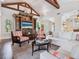Inviting living room featuring vaulted ceilings with wood beams, comfortable seating, and a custom built-in entertainment center at 7333 Point Of Rocks Rd, Sarasota, FL 34242