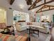 Comfortable living room with an open floor plan, hardwood floors and vaulted ceilings with wooden beams at 7333 Point Of Rocks Rd, Sarasota, FL 34242