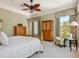 Relaxing main bedroom with a sitting chair, wood furnishings, and two windows at 7333 Point Of Rocks Rd, Sarasota, FL 34242