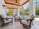 Outdoor seating area with fireplace, ceiling fans and pool views at 7333 Point Of Rocks Rd, Sarasota, FL 34242