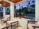A covered patio features an outdoor fireplace and ample seating for guests at 7333 Point Of Rocks Rd, Sarasota, FL 34242