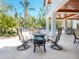Relaxing covered patio with comfortable seating, overlooking the pool and lush tropical landscaping at 7333 Point Of Rocks Rd, Sarasota, FL 34242