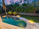 An aerial view of a private in-ground pool surrounded by lush landscaping and a stone patio at 7333 Point Of Rocks Rd, Sarasota, FL 34242