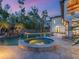 The backyard pool with spa are illuminated and surrounded by stone pavers at 7333 Point Of Rocks Rd, Sarasota, FL 34242