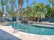 Captivating backyard pool with a rock waterfall feature, enhanced by lush tropical foliage at 7333 Point Of Rocks Rd, Sarasota, FL 34242
