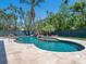 Stunning custom pool with a rock waterfall feature, surrounded by lush tropical landscaping at 7333 Point Of Rocks Rd, Sarasota, FL 34242
