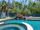 Inviting backyard pool and spa with rock waterfall feature, surrounded by tropical landscaping at 7333 Point Of Rocks Rd, Sarasota, FL 34242