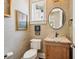 Stylish powder room with grasscloth wallpaper, decorative art, and a round mirror at 7333 Point Of Rocks Rd, Sarasota, FL 34242