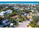 This aerial view showcases the property's proximity to the beach, surrounded by lush trees in a vibrant neighborhood at 734 Canal Rd, Sarasota, FL 34242