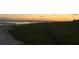 Sunset view of the beach with lush grass and calm ocean, perfect for evening strolls at 734 Canal Rd, Sarasota, FL 34242