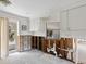 Kitchen with white cabinets, open studs ready for renovation, and a view to the backyard through a window at 734 Canal Rd, Sarasota, FL 34242